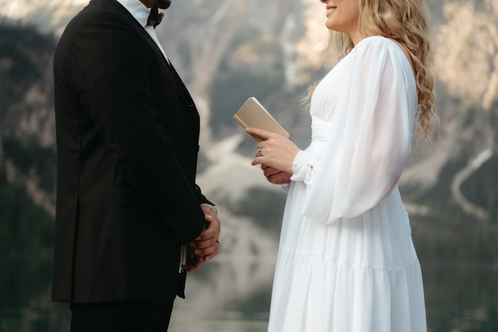 Couple reading personal wedding vows during an outdoor ceremony
